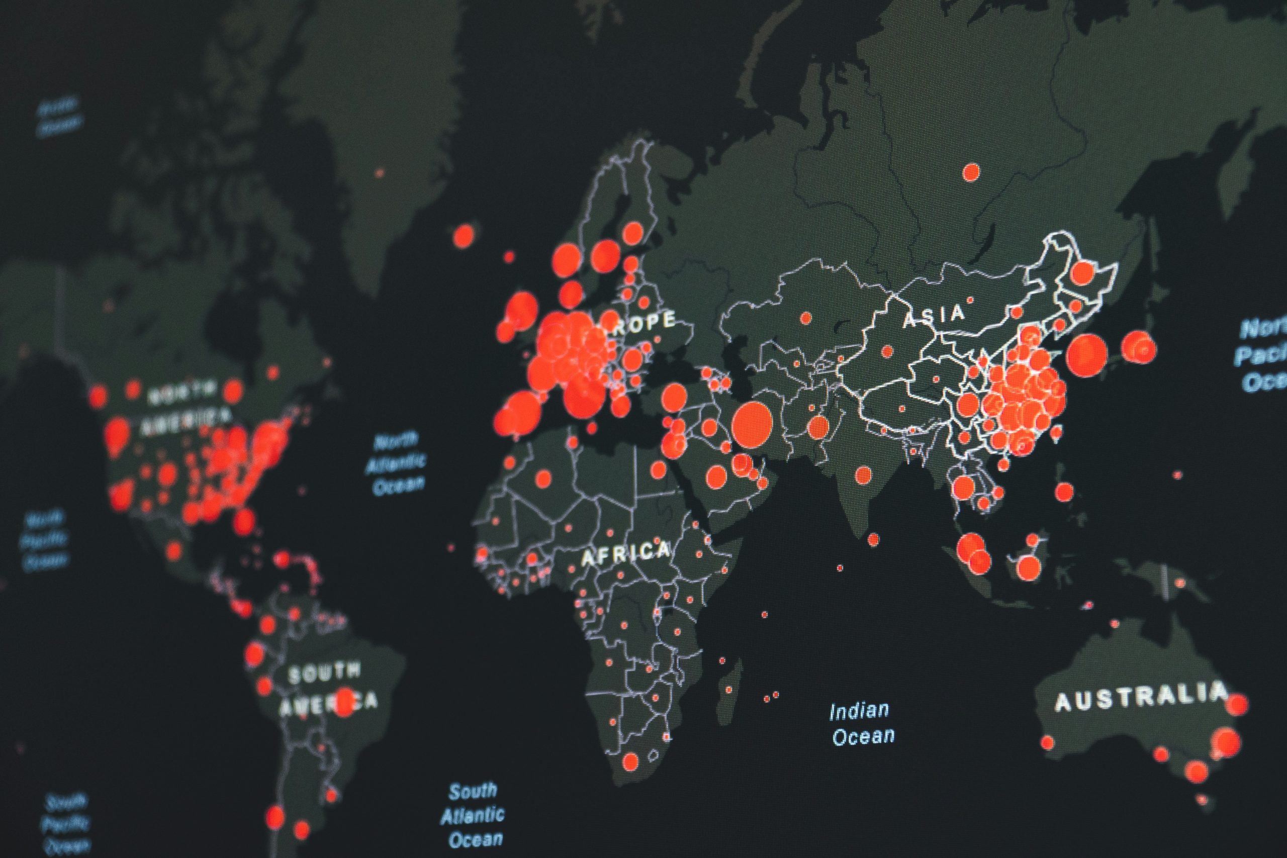 A dark world map overlaid with red circles of varying sizes marking sites of contagion, concentrated across Asia and the Americas.